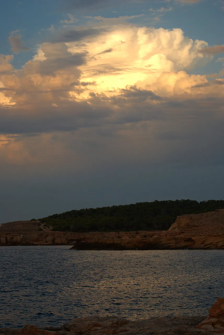 Abendwolken über der felsigen Landspitze von Cala Bassa