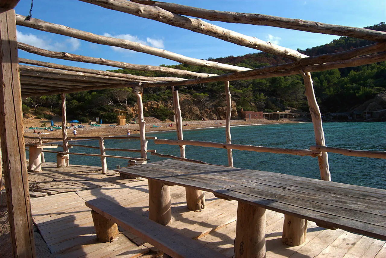 Bajo la pérgola de madera, con la playa al otro lado