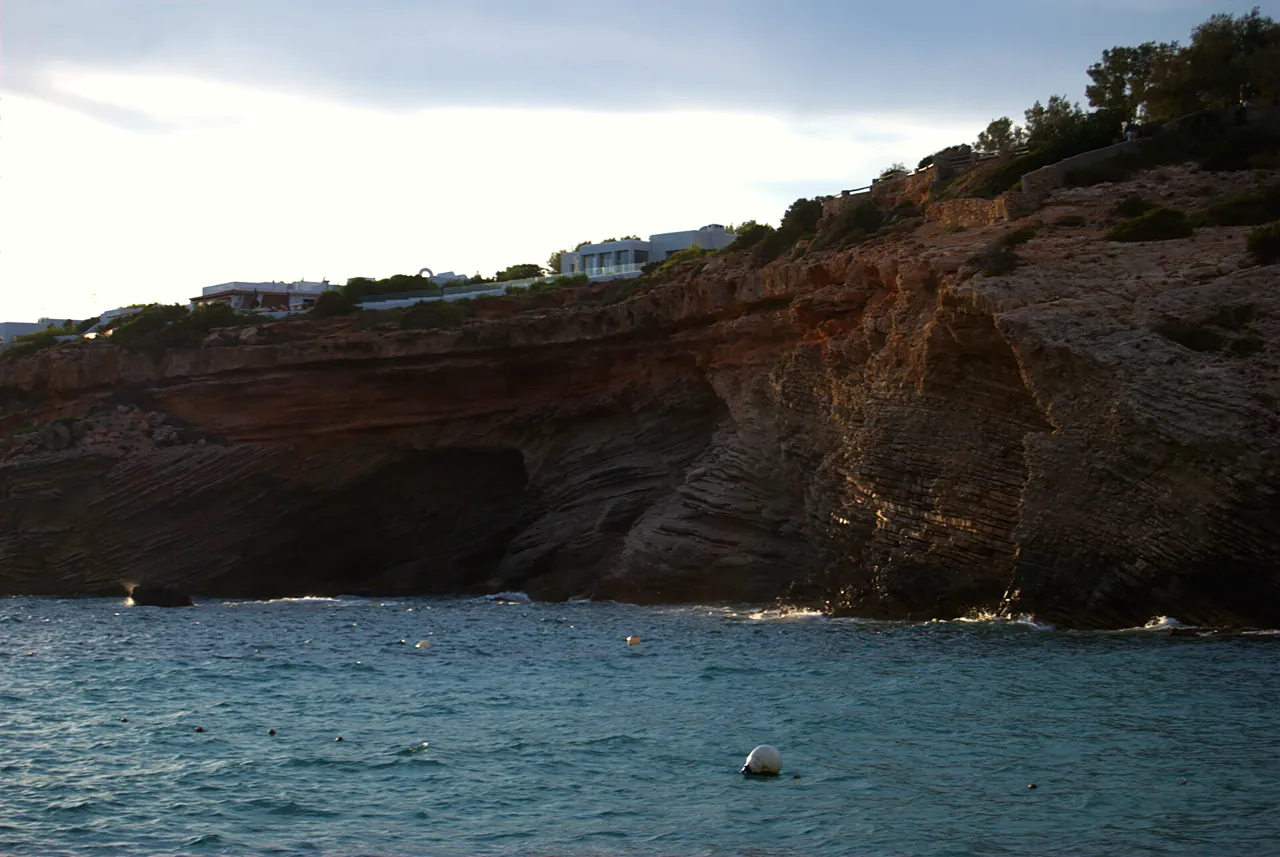 Rötliche Klippe über dem Wasser von Cala Codolar