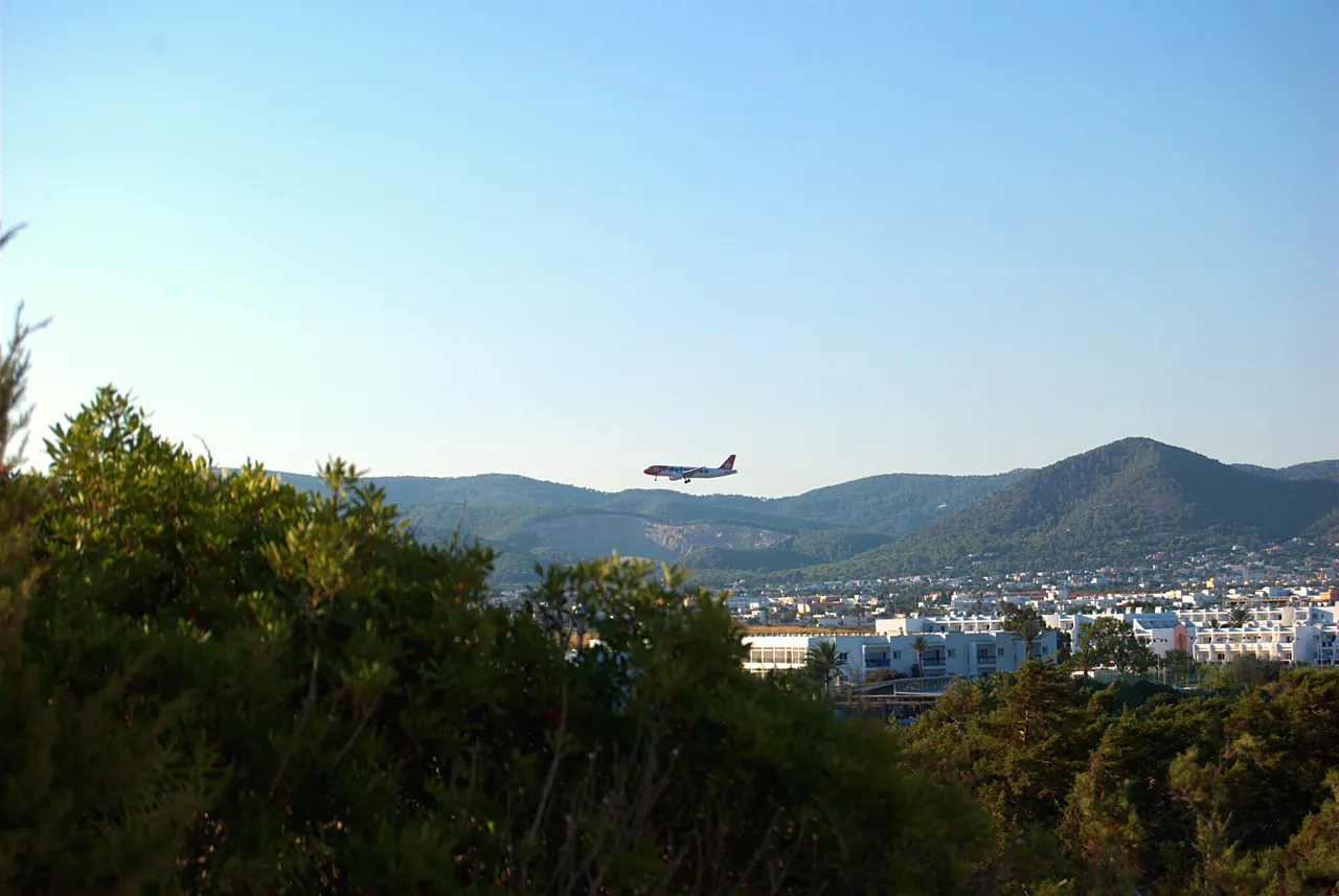 Vliegtuig landt over de pijnbomen bij Platja d'en Bossa