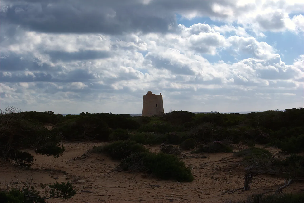 Torre de ses Portes entre las dunas y la sabina bajo nubes